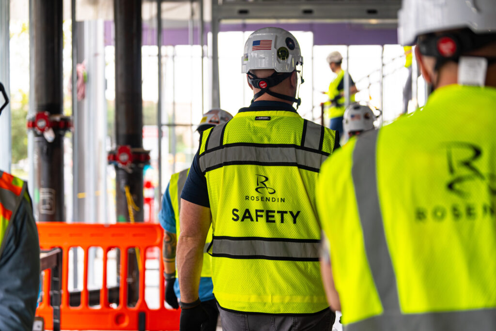 Rosendin Safety team member walking through work site with electricians and supers